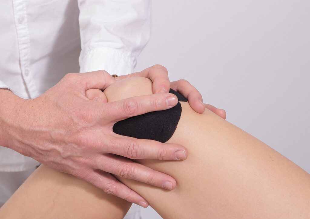 Therapist providing knee taping and sports massage
