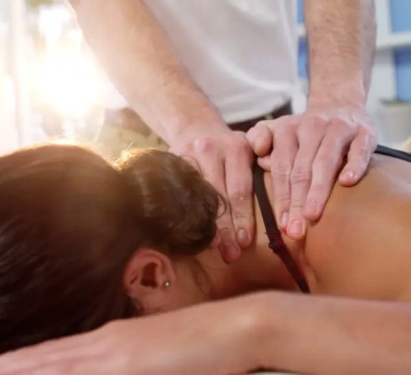Woman Receiving Massage Therapy Lying Face Down for Rehabilitation & Pain